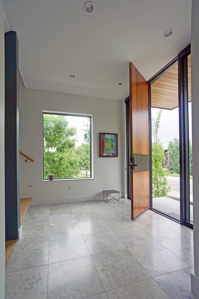 Foto de distribuidor moderno grande con paredes blancas, suelo de piedra caliza, puerta simple, suelo gris y puerta de madera en tonos medios