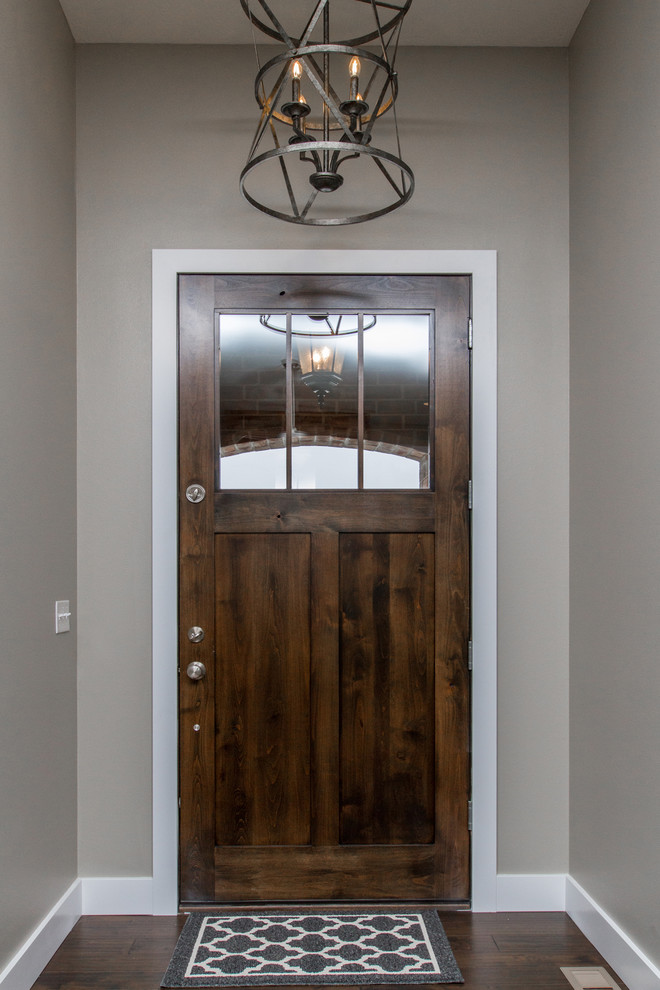 Идея дизайна: входная дверь среднего размера в стиле неоклассика (современная классика) с серыми стенами, темным паркетным полом, одностворчатой входной дверью и входной дверью из темного дерева