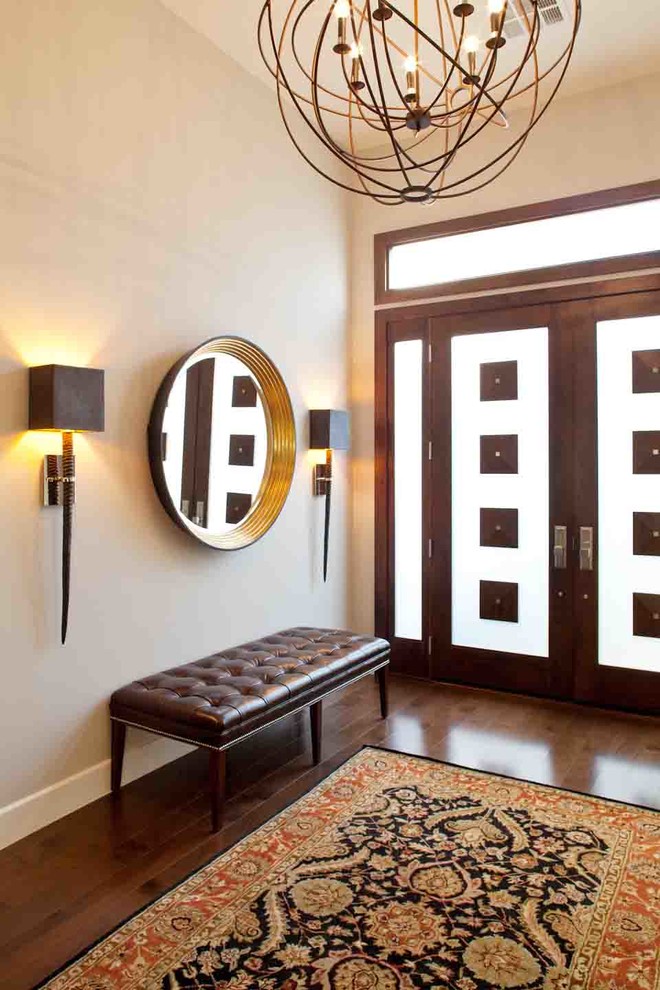 Réalisation d'un très grand hall d'entrée design avec un mur beige, un sol en bois brun, une porte double, une porte en bois brun et un sol marron.