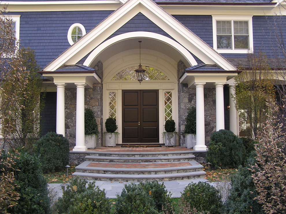 Idée de décoration pour une porte d'entrée victorienne avec une porte double et une porte en bois foncé.