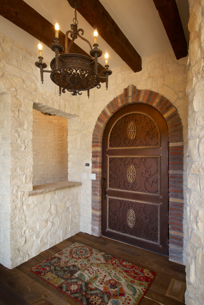 Exempel på en stor medelhavsstil ingång och ytterdörr, med vita väggar, mörkt trägolv, en enkeldörr och en brun dörr