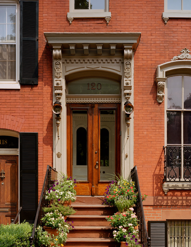 Immagine di una porta d'ingresso tradizionale con una porta a due ante e una porta in legno bruno