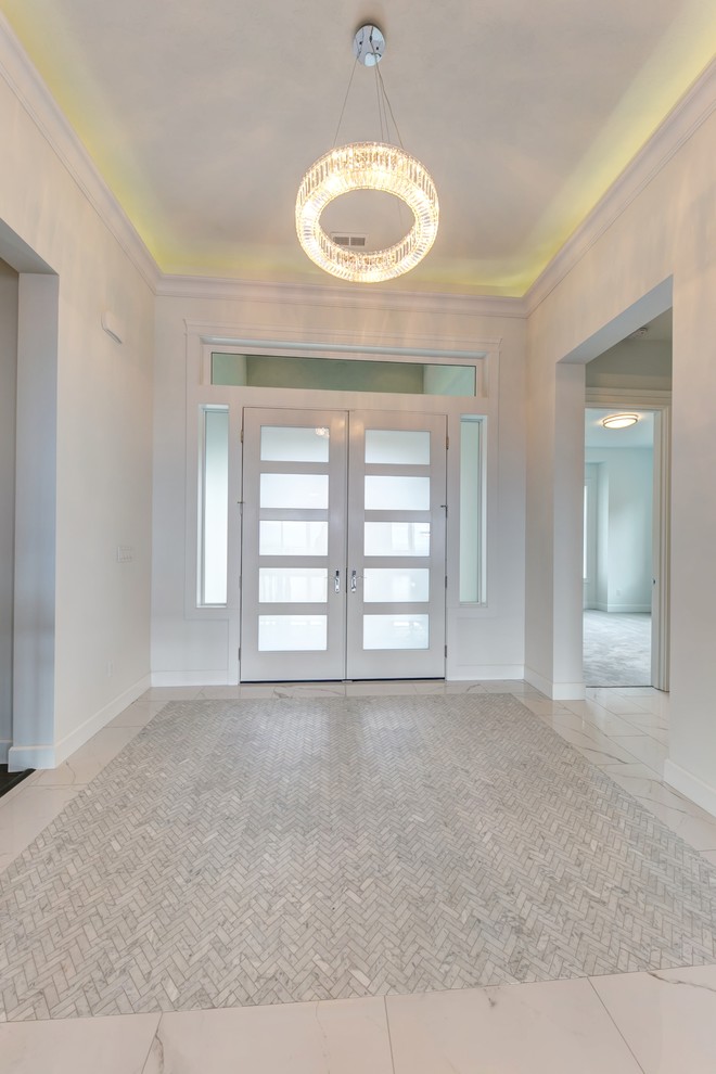 Пример оригинального дизайна: входная дверь среднего размера в стиле модернизм с белыми стенами, мраморным полом, двустворчатой входной дверью, белой входной дверью и белым полом