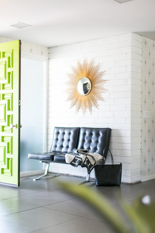 Large mid-century modern ceramic tile, gray floor and brick wall foyer photo in Orange County with white walls and a green front door