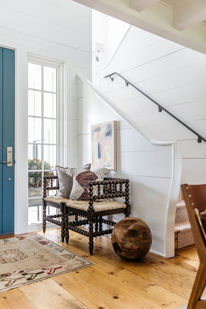 Country Foyer mit weißer Wandfarbe, blauer Haustür, braunem Boden, braunem Holzboden und Einzeltür in Sonstige
