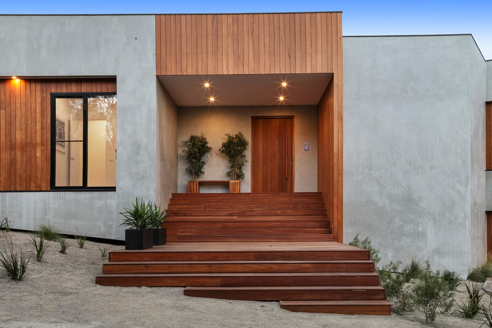 Modelo de puerta principal contemporánea con paredes grises, suelo de madera en tonos medios, puerta simple, puerta marrón y suelo marrón