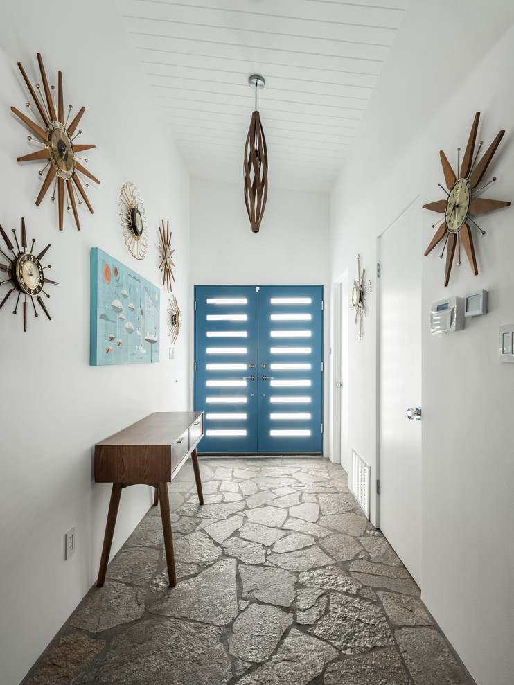 Ispirazione per una porta d'ingresso minimalista di medie dimensioni con pareti bianche, pavimento in ardesia, una porta a due ante, una porta blu e pavimento multicolore