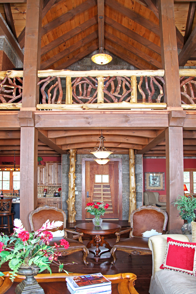Imagen de puerta principal rural grande con paredes rojas, suelo de madera en tonos medios, puerta simple y puerta de madera en tonos medios