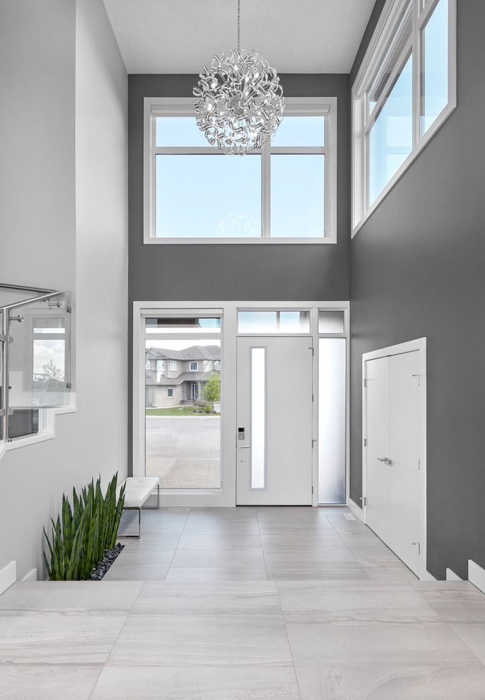 Ejemplo de puerta principal contemporánea grande con paredes grises, suelo de baldosas de porcelana, puerta simple, puerta blanca y suelo gris