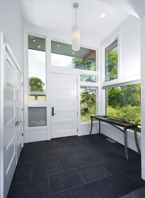 Идея дизайна: маленькая входная дверь в стиле ретро с белыми стенами, полом из сланца, одностворчатой входной дверью, белой входной дверью и черным полом для на участке и в саду