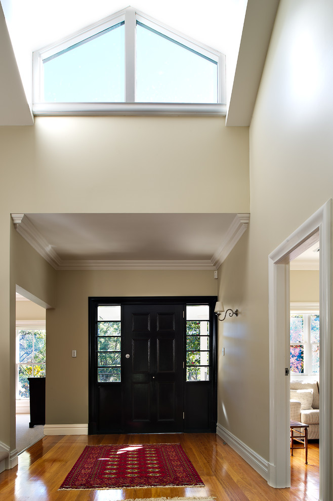Photo of a medium sized contemporary foyer in Sydney with medium hardwood flooring, a single front door and a black front door.