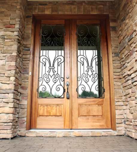 タンパにある高級な中くらいな地中海スタイルのおしゃれな玄関ドア (茶色い壁、レンガの床、淡色木目調のドア) の写真