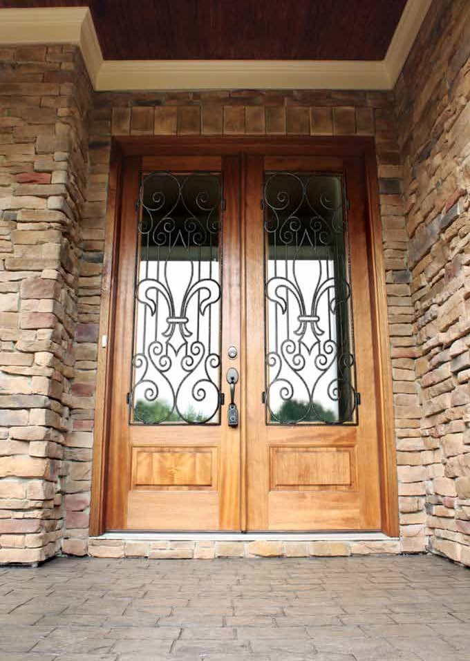 Foto de puerta principal mediterránea de tamaño medio con paredes marrones, suelo de ladrillo, puerta doble y puerta de madera clara