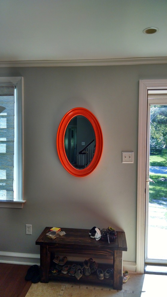 Imagen de puerta principal actual pequeña con paredes grises, suelo de madera en tonos medios, puerta simple, puerta naranja y suelo marrón