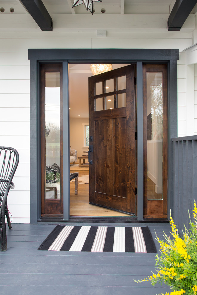 Immagine di una porta d'ingresso country di medie dimensioni con una porta singola, una porta in legno scuro, pavimento beige e pavimento in legno massello medio