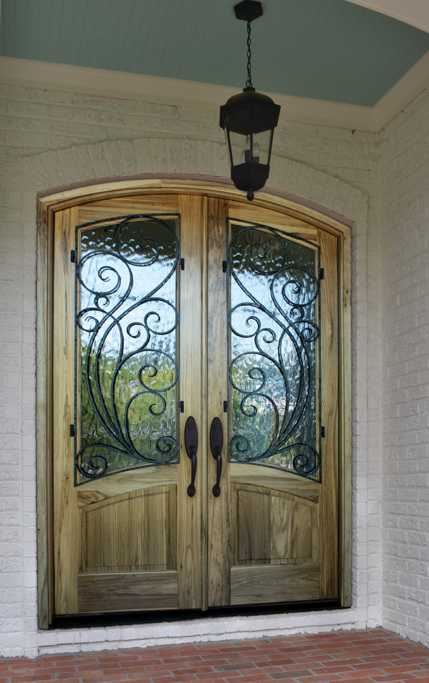 Example of a mountain style brick floor entryway design in Charlotte with white walls and a medium wood front door