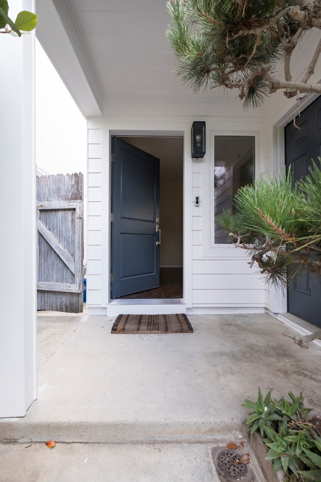 Idéer för en liten lantlig ingång och ytterdörr, med vita väggar, betonggolv, en enkeldörr, en blå dörr och grått golv