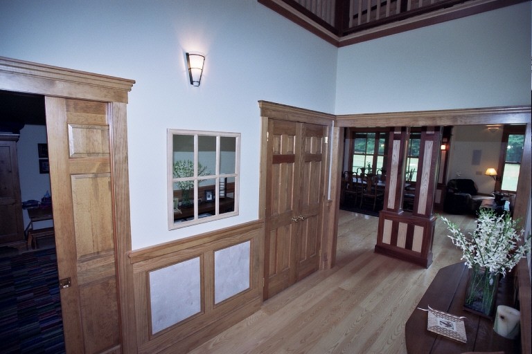 Idée de décoration pour un grand hall d'entrée tradition avec un mur beige, parquet clair, une porte simple et une porte en bois foncé.