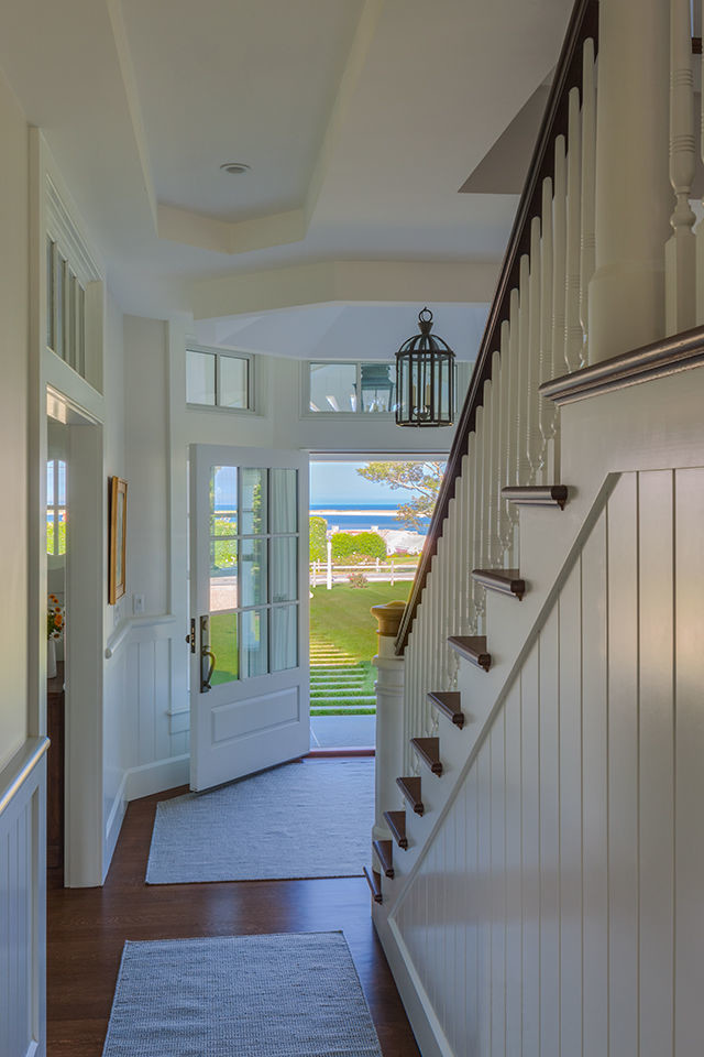 This is an example of a medium sized nautical foyer in Boston with white walls, dark hardwood flooring, a single front door, a white front door and brown floors.
