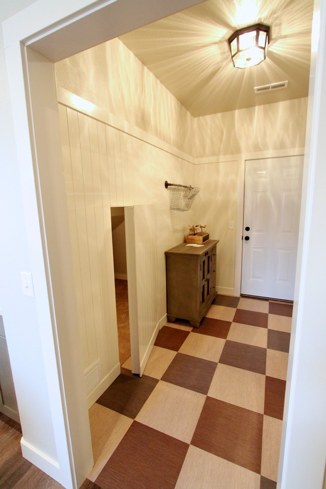 Aménagement d'une entrée campagne de taille moyenne avec un couloir, un mur gris, un sol en vinyl, une porte simple et une porte blanche.