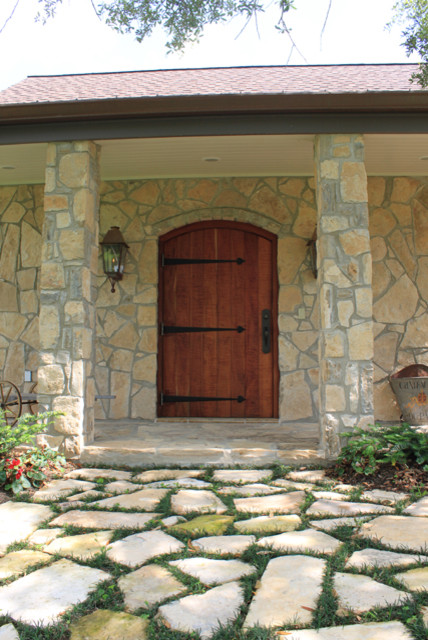 Idee per una porta d'ingresso chic di medie dimensioni con pavimento in pietra calcarea, una porta singola, una porta in legno bruno e pavimento beige