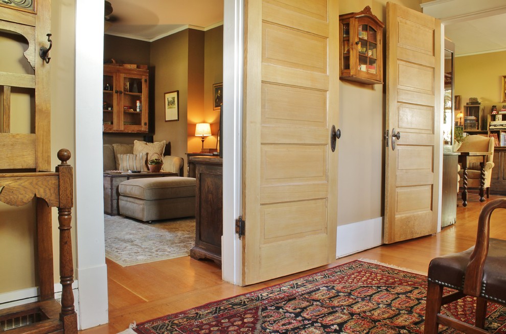 Modelo de entrada campestre con paredes beige y suelo de madera en tonos medios