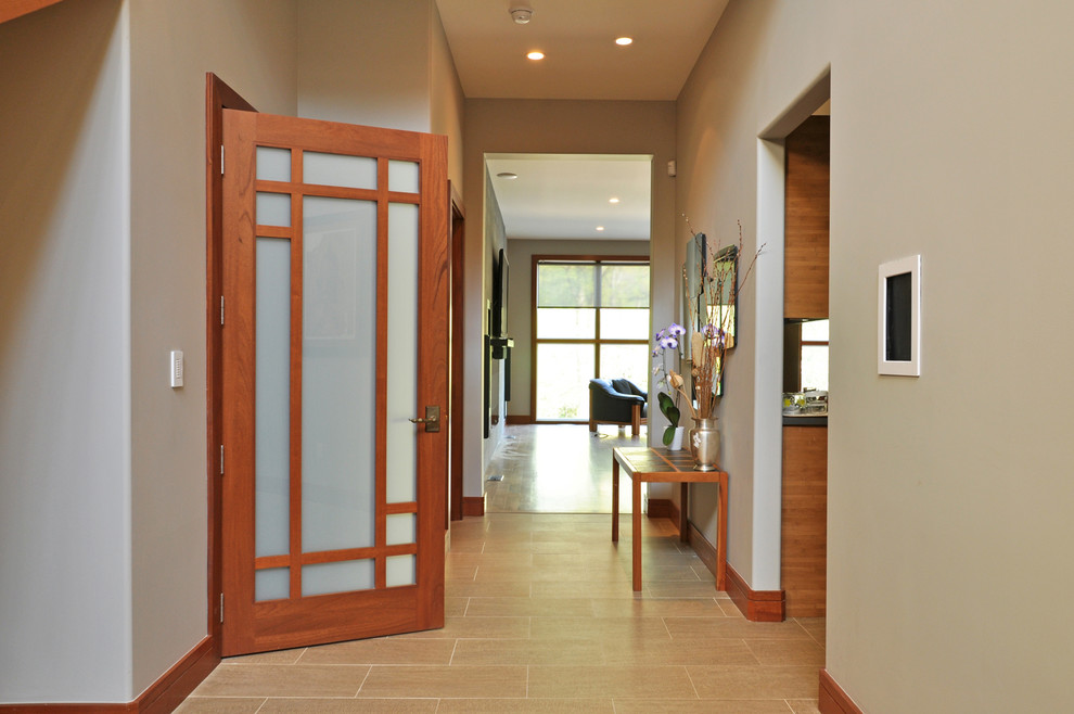 Ispirazione per una porta d'ingresso contemporanea di medie dimensioni con pareti beige, una porta singola, una porta in legno bruno, pavimento in gres porcellanato e pavimento beige