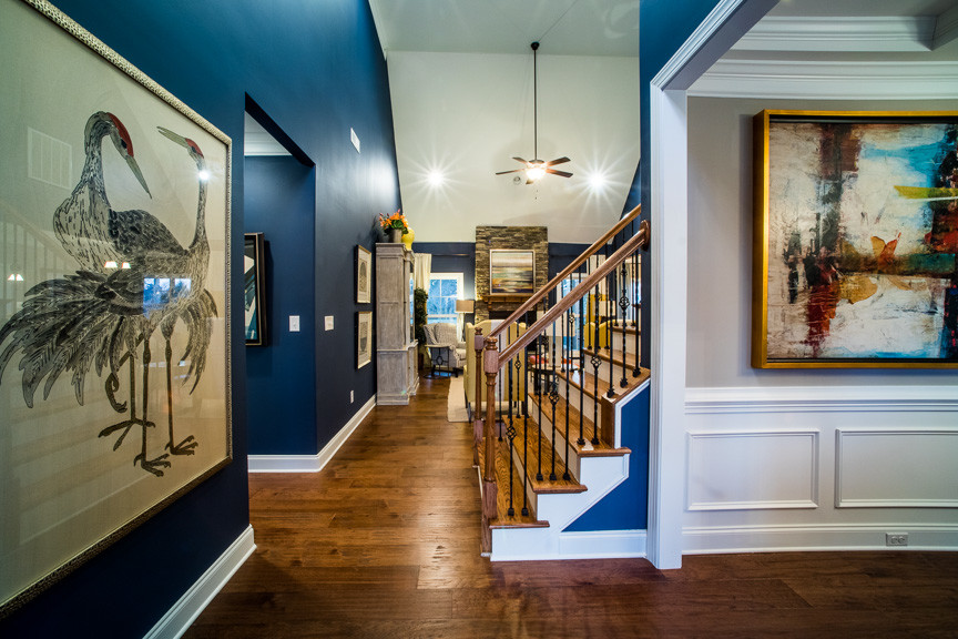На фото: фойе в классическом стиле с синими стенами, темным паркетным полом, одностворчатой входной дверью и входной дверью из дерева среднего тона с