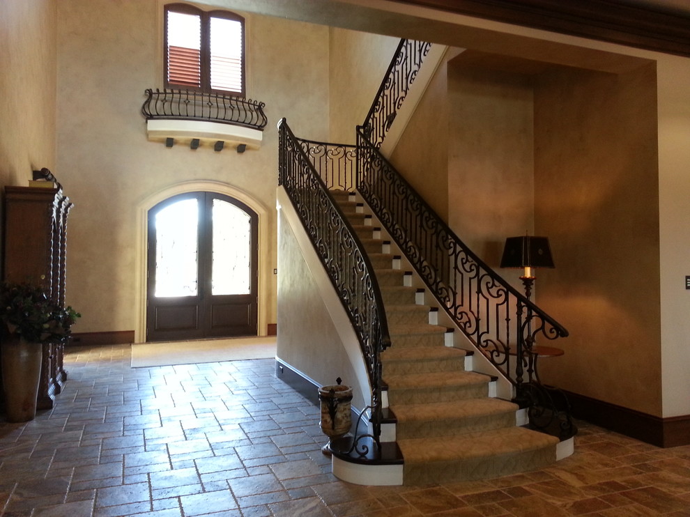 Large tuscan travertine floor entryway photo in Orlando with beige walls and a dark wood front door