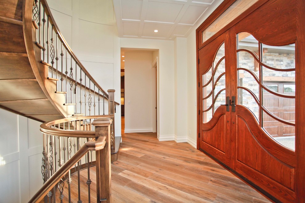 Klassisches Foyer mit weißer Wandfarbe, braunem Holzboden und hellbrauner Holzhaustür in Calgary