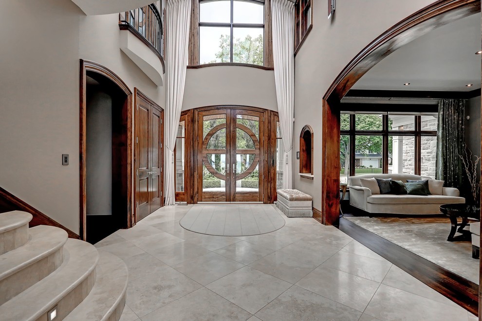 Aménagement d'un hall d'entrée classique avec un mur gris, un sol en carrelage de porcelaine, une porte double et une porte en bois brun.