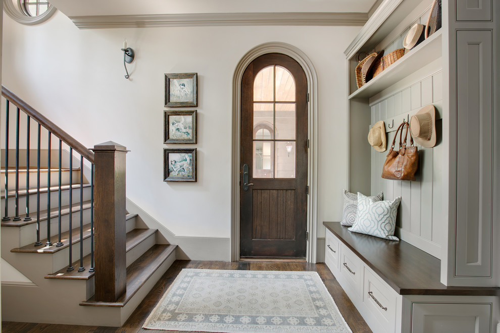 Photo of a traditional foyer in Other with white walls, dark hardwood flooring, a single front door, a dark wood front door and brown floors.