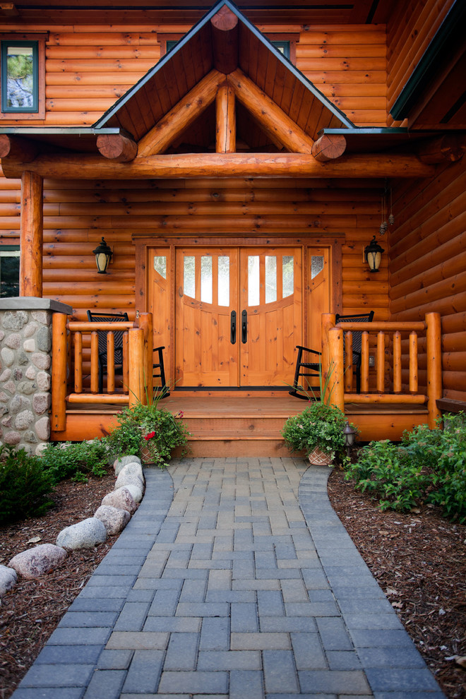 Foto di una porta d'ingresso stile rurale con una porta a due ante e una porta in legno bruno