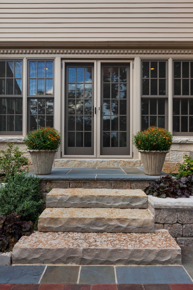 This is an example of a classic front door in Milwaukee with beige walls, a double front door and a grey front door.