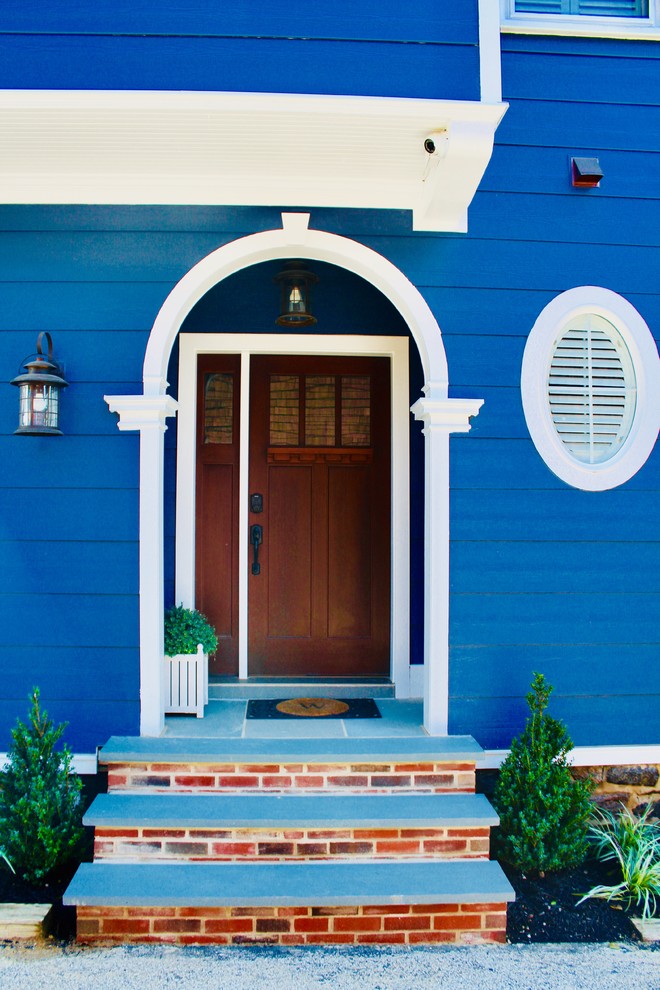 Пример оригинального дизайна: входная дверь в классическом стиле с синими стенами, одностворчатой входной дверью, входной дверью из дерева среднего тона и синим полом