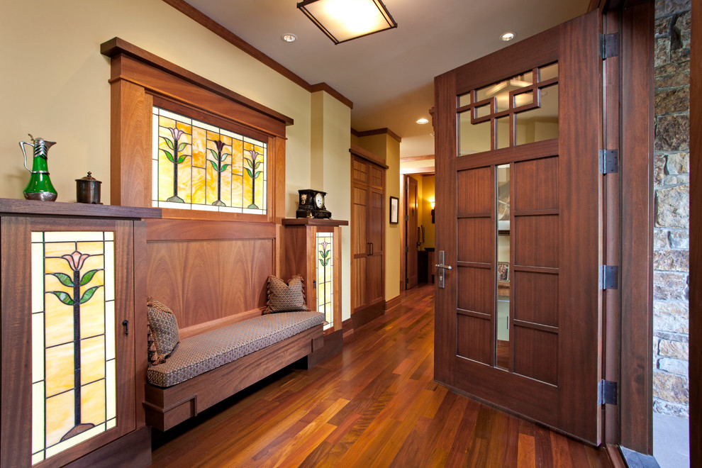 Imagen de entrada de estilo americano con paredes beige, suelo de madera en tonos medios, puerta simple y puerta de madera oscura