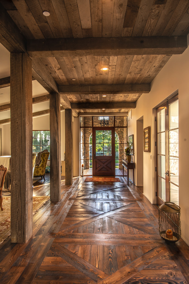 Uriger Eingang mit beiger Wandfarbe, dunklem Holzboden, Einzeltür, dunkler Holzhaustür und braunem Boden in Los Angeles