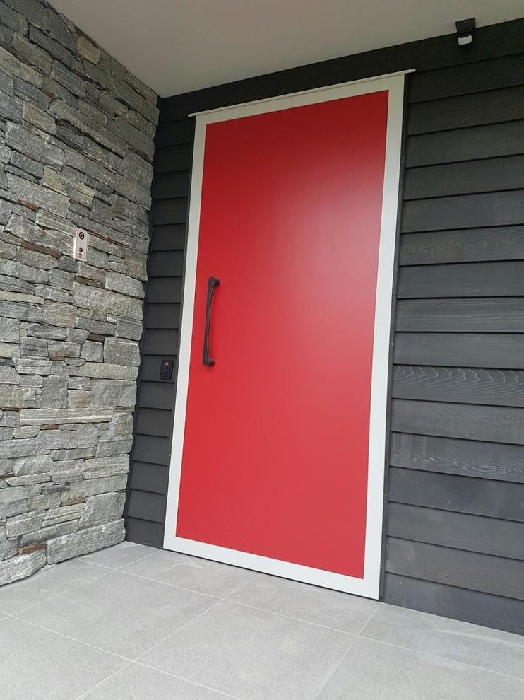 Idées déco pour une grande porte d'entrée moderne avec un mur rouge, un sol en carrelage de porcelaine et une porte simple.
