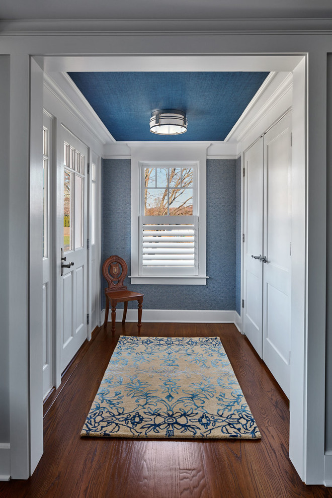 Idées déco pour une petite porte d'entrée éclectique avec un mur bleu, une porte simple, une porte blanche, un sol en bois brun et un sol marron.