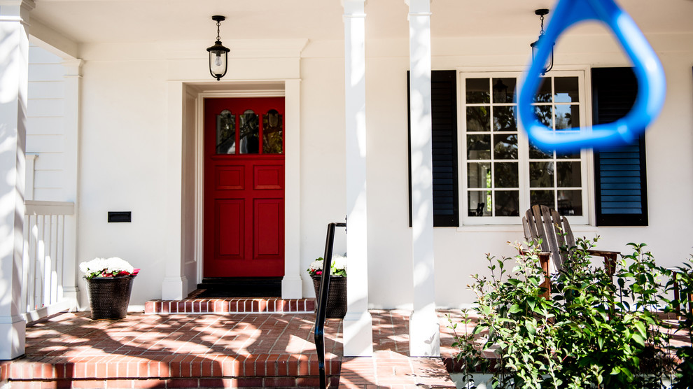 Стильный дизайн: прихожая среднего размера в классическом стиле с белыми стенами, кирпичным полом, одностворчатой входной дверью, красной входной дверью и красным полом - последний тренд