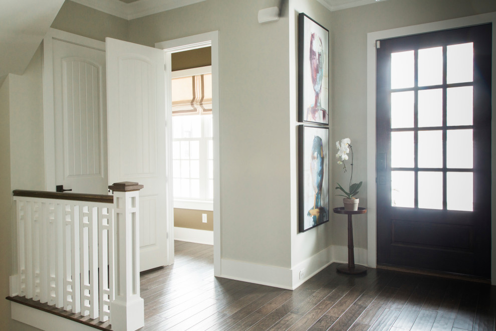 Ispirazione per un ingresso classico di medie dimensioni con pareti beige, parquet scuro, una porta singola, una porta in legno scuro e pavimento marrone