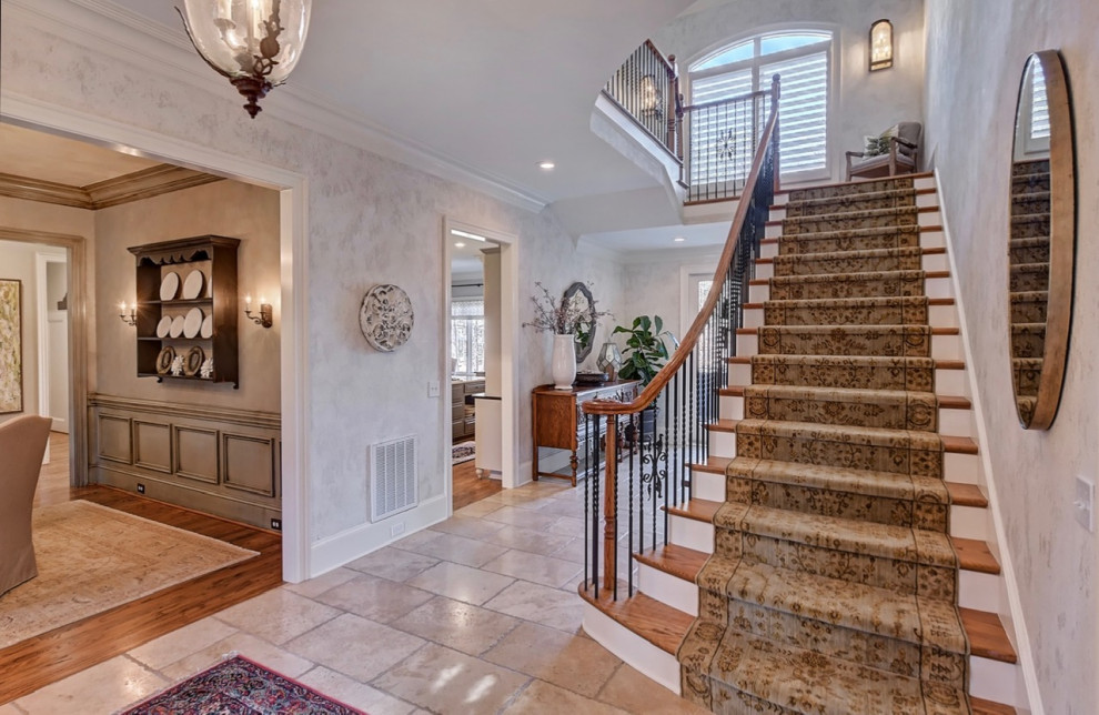 Large foyer in Charlotte with white walls, travertine flooring and beige floors.