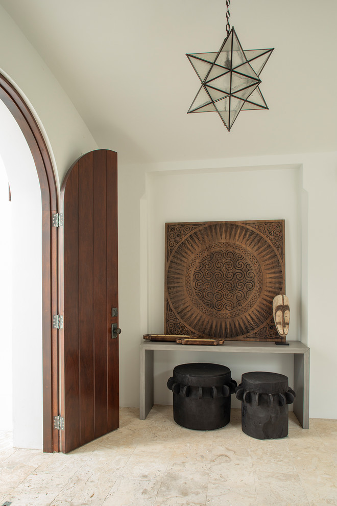 Large beach style beige floor entryway photo with white walls and a dark wood front door