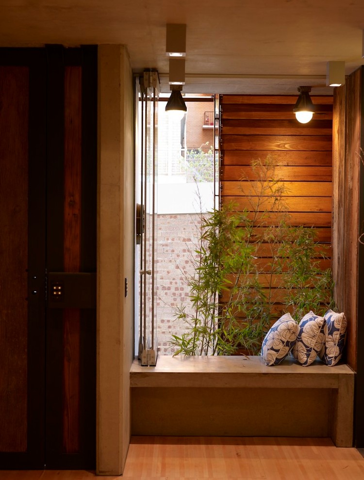 Inspiration pour un petit hall d'entrée urbain avec un mur marron, un sol en bois brun, une porte simple, une porte en bois brun et un sol beige.