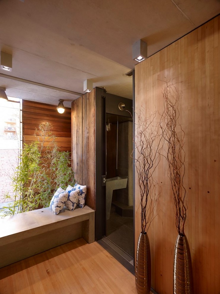 Ispirazione per un piccolo ingresso moderno con pareti marroni e pavimento in legno massello medio