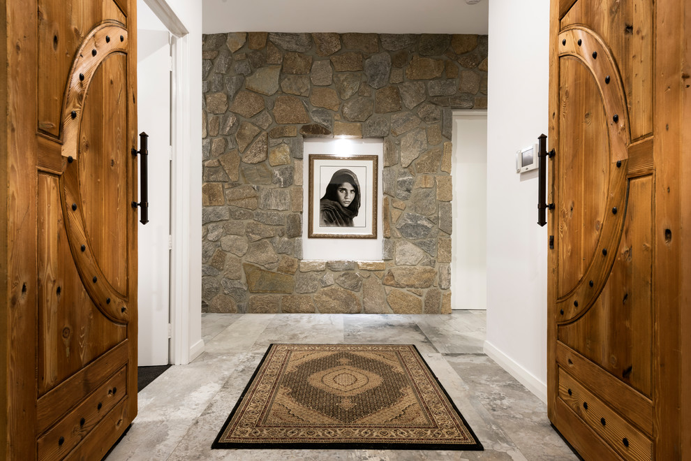 Imagen de puerta principal mediterránea con paredes blancas, puerta doble, puerta de madera en tonos medios y suelo gris