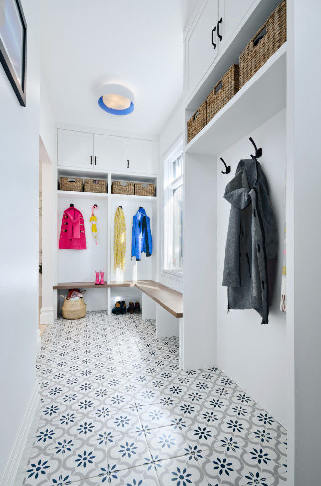 Cette photo montre une petite entrée chic avec un vestiaire, un mur blanc et un sol en carrelage de céramique.
