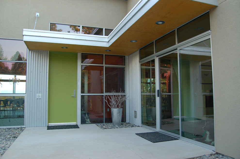 Idee per una grande porta d'ingresso contemporanea con pareti beige, pavimento in cemento, una porta singola e una porta verde