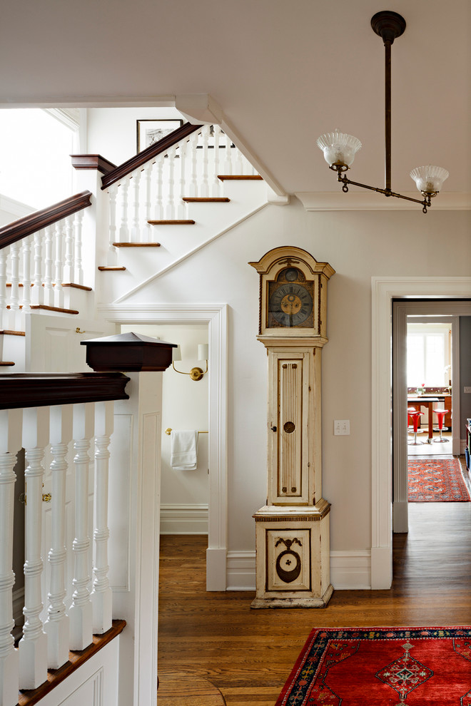 Example of an ornate dark wood floor foyer design in Portland with white walls