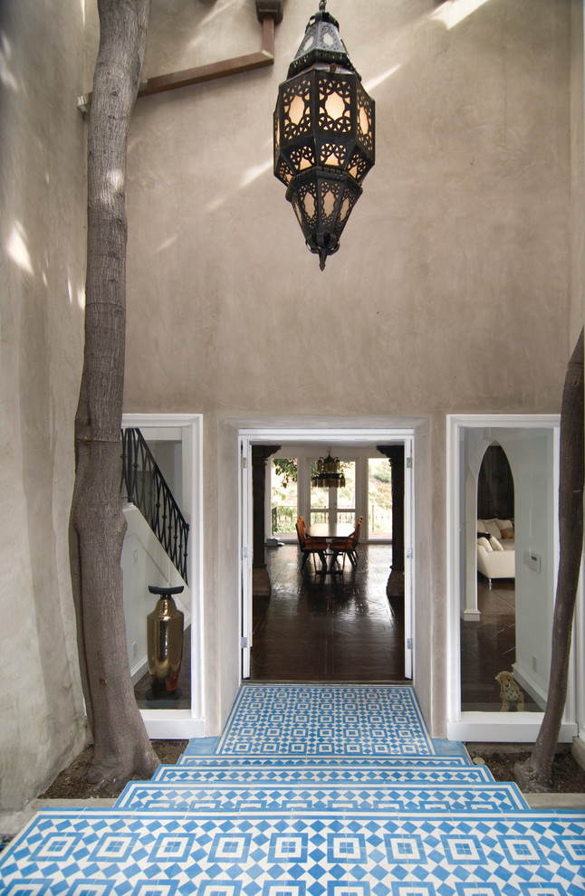 Mediterranean entrance in Los Angeles with beige walls, a double front door and blue floors.